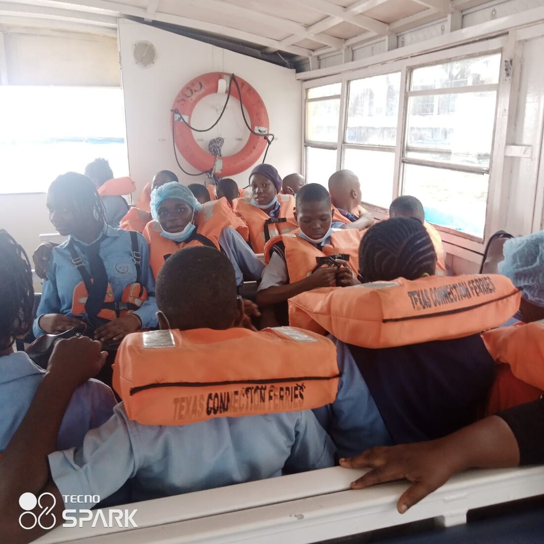 Adetola students wearing life jackets aboard a ferry