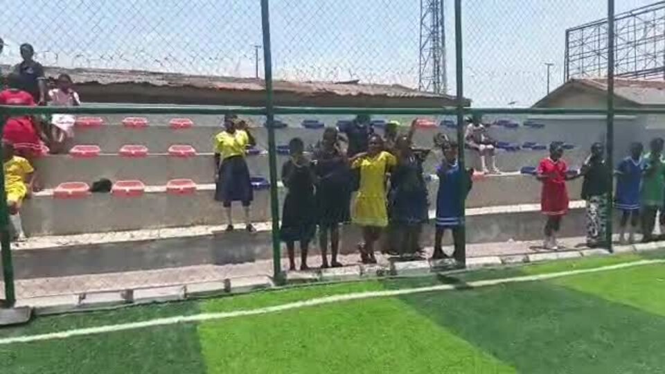 Adetola students cheering from the stands at a sports event